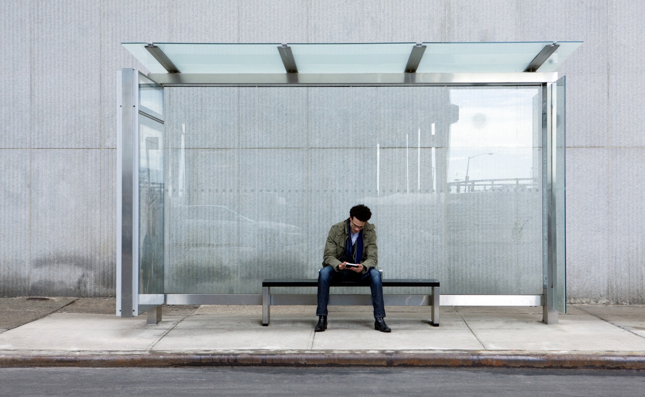 Man using smartphone bus stop